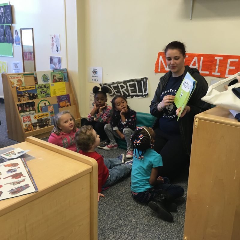 Husky Reads Student with Children